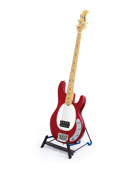 A red electric guitar displayed on a stand with a clean white background, featuring the Music Man Stingray 4 H Bass, USA 2008.