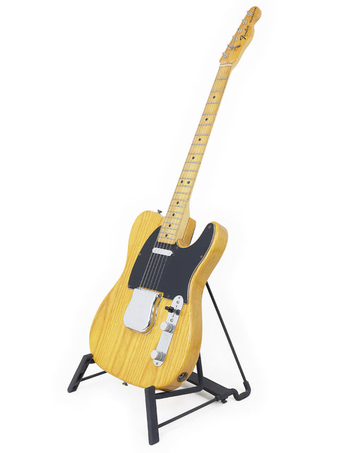  A small vintage Fender Telecaster electric guitar from 1977-78, elegantly positioned on a stand, highlighting its iconic shape.