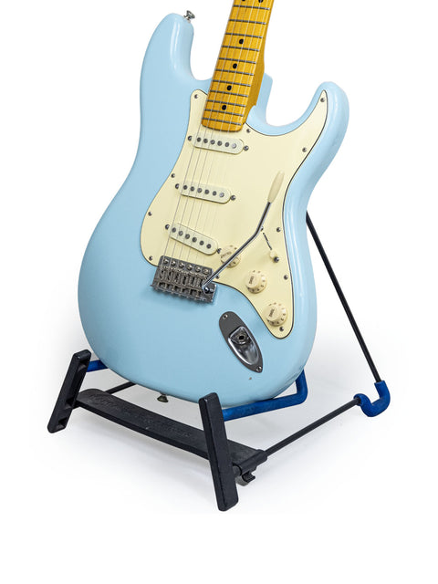 A striking blue electric guitar on a stand, featuring a Warmoth Strat Partscaster made in the USA in 2012.