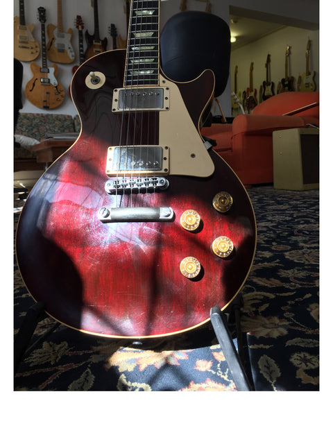 A striking red Gibson Les Paul Standard guitar from 1991 is positioned on a stand, enhancing the room's musical ambiance.