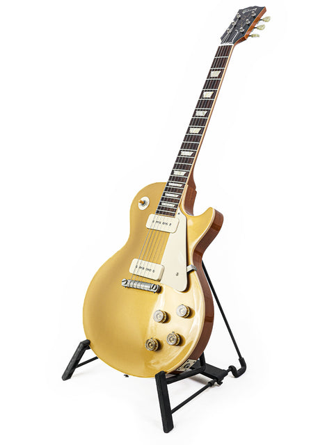 A stunning gold electric guitar, the Gibson Les Paul LPR-4 1954 Reissue, resting on a stand.