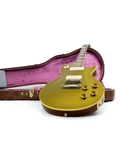 A stunning gold guitar nestled in a case against a white backdrop, featuring the Gibson Custom Historic Limited Edition 1956 Les Paul.
