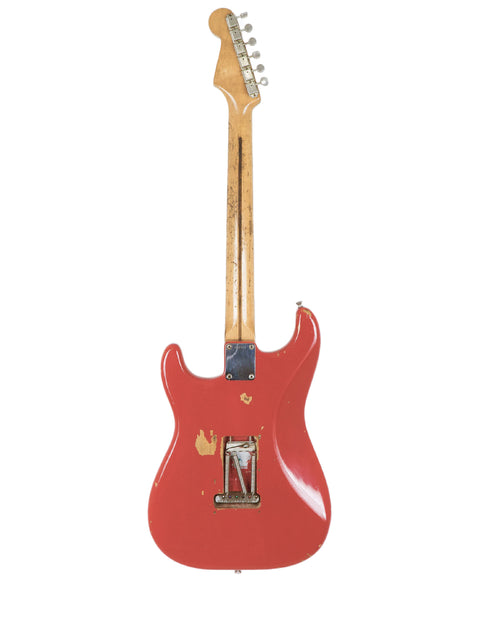 A stunning red 1958 Fender Stratocaster with a wooden body and neck, embodying timeless style and craftsmanship.
