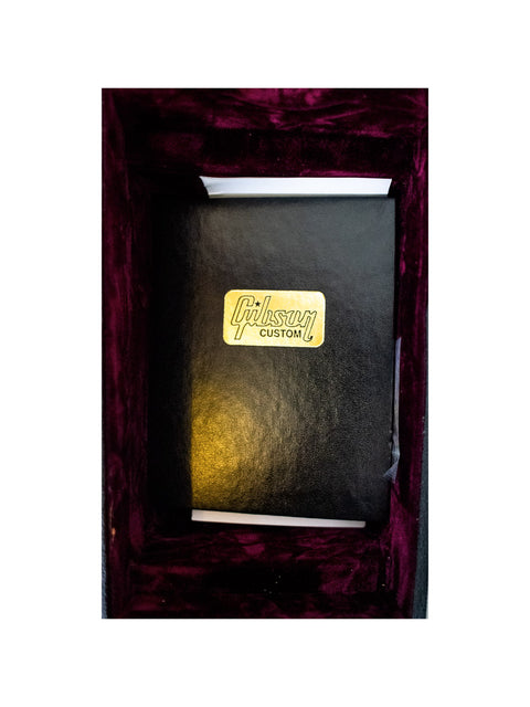 A stylish black and gold book with a gold label, showcasing the 'Gibson Custom Shop Wildwood Spec 1961 SG Standard Reissue'.
