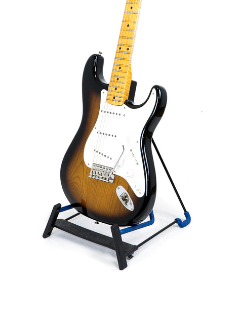 A sunburst electric guitar lying on a white background.