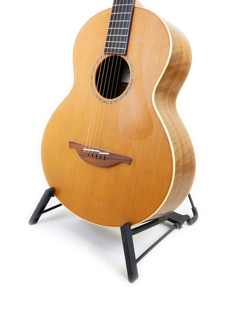 A unique Lowden S-35 1 of 1 Prototype guitar resting on a stand with a white background.