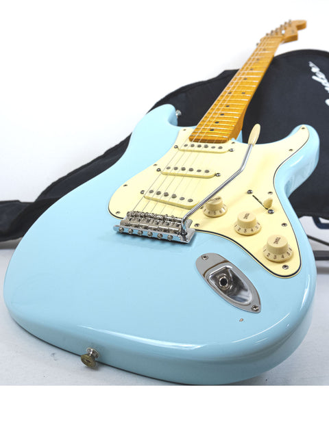 A vibrant blue electric guitar with a black case, representing a 2012 Warmoth Strat Partscaster made in the USA.