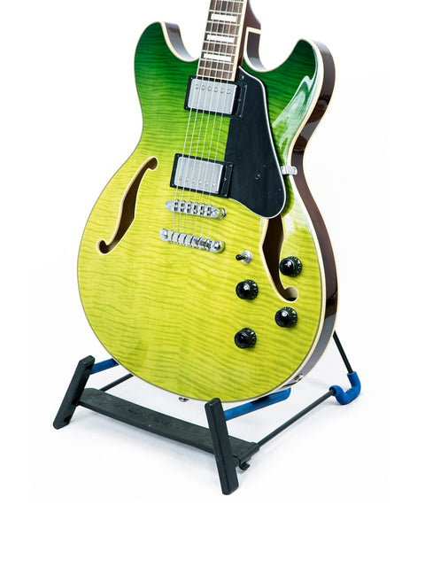 A vibrant green Ibanez Artcore AS73 FM guitar displayed on a black stand, highlighting its semi-hollow body style.
