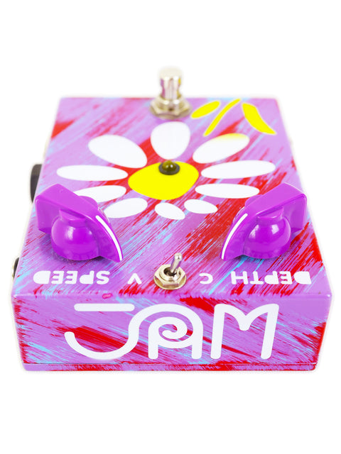 A vibrant purple pedal box adorned with a flower, identified as JAM Pedals RetroVibe mk.2 from Greece.
