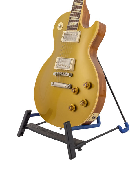 A vibrant yellow Gibson Custom Shop LPR-7 1957 Les Paul Goldtop guitar resting on a stand, highlighting its iconic shape.
