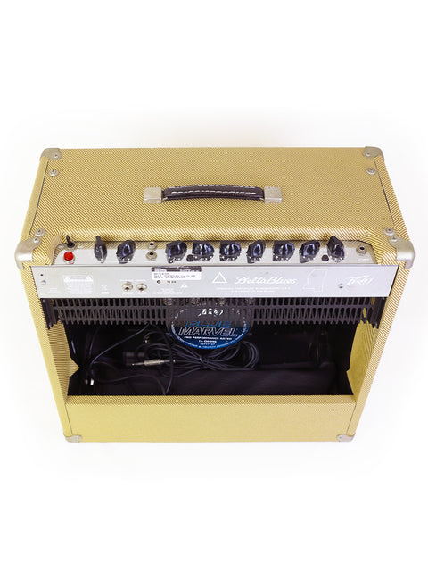 A vibrant yellow Peavey Delta Blues 115 guitar amp set against a contrasting black and white backdrop.

