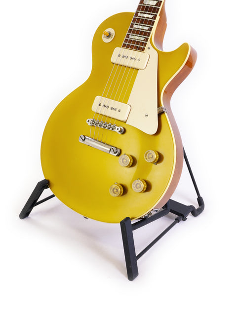 A vibrant yellow electric guitar displayed on a stand, featuring the Gibson Custom Historic VOS LPR-6 1956 Reissue Gold Top.
