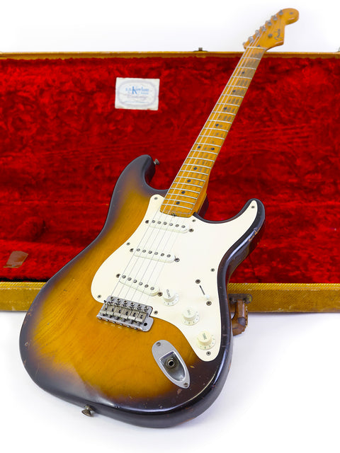 A vintage 1954 Fender Stratocaster guitar nestled in a case, highlighting its iconic shape and historical significance.