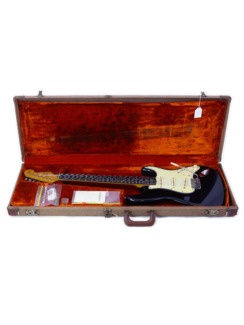 A vintage 1963 Fender Stratocaster electric guitar in black, highlighting its iconic shape and rich musical heritage.