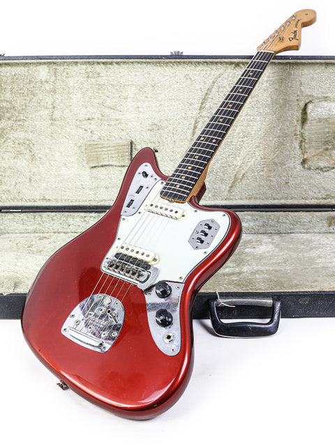 A vintage 1964 L-Series Fender Jaguar guitar, featuring a red wooden body and neck, symbolizing classic American craftsmanship.