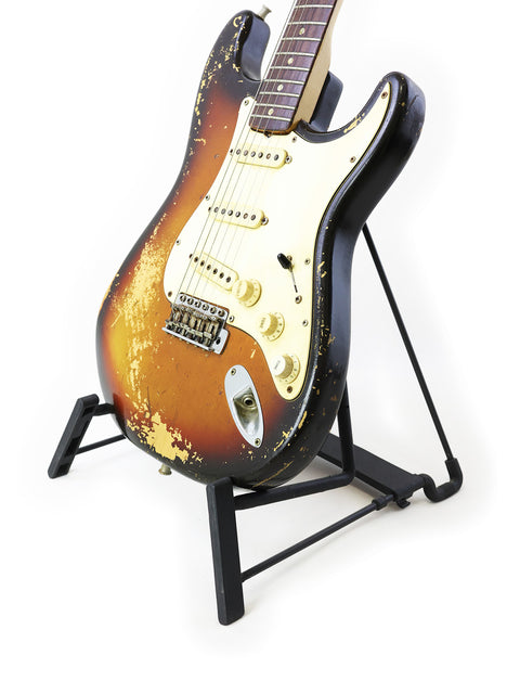 A vintage 1970 Fender Stratocaster guitar elegantly displayed on a stand with a pristine white backdrop.