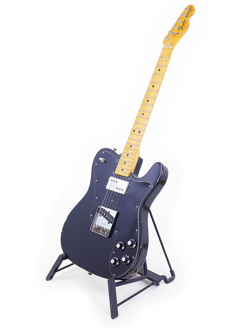 A vintage 1978 black Fender Telecaster Custom electric guitar resting on a stand, showcasing its classic design.