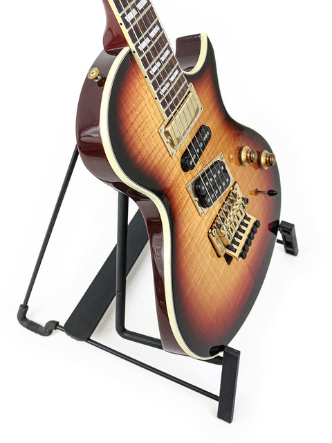 A vintage 1997 Gibson Nighthawk guitar resting on a stand, set against a solid black background.