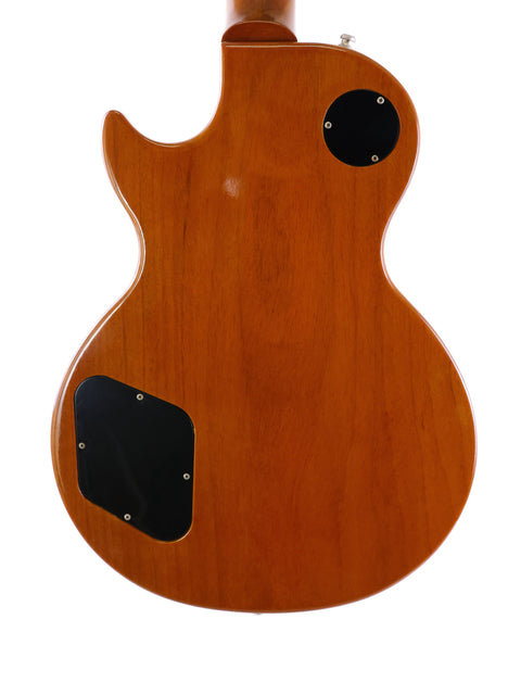 A vintage Gibson Les Paul Classic 1960 Reissue guitar featuring a wooden body and sleek black buttons, highlighting its iconic style.