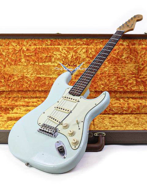 A white '59 Stratocaster electric guitar from Fender's Custom Shop, nestled in its case, highlighting its craftsmanship.