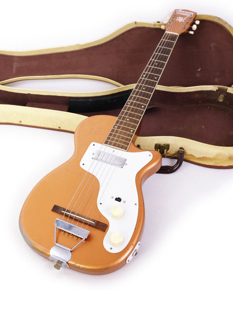 A white background features a 1955 Harmony H44 Stratotone guitar with its protective case.