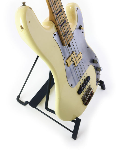 A white electric bass guitar, the Ibanez Silver Series P/J from 1978, elegantly positioned on a stand.
