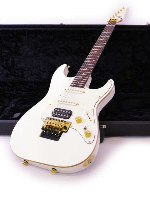 A white electric guitar displayed in a black case, the Tom Anderson Drop Top Classic model from the USA, 2014.