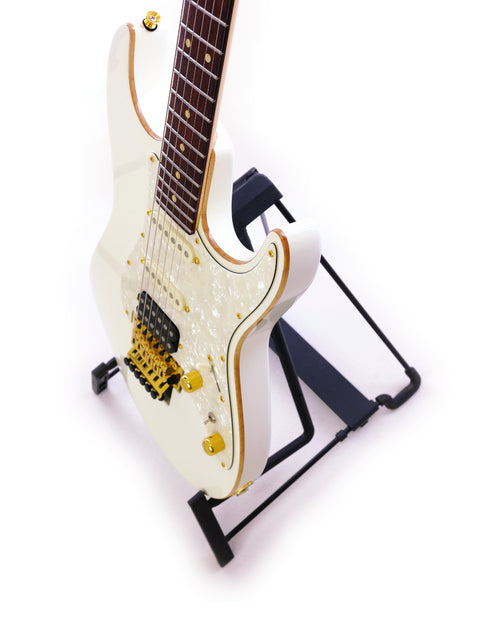A white guitar, the Tom Anderson Drop Top Classic from 2014, displayed on a sturdy black stand.