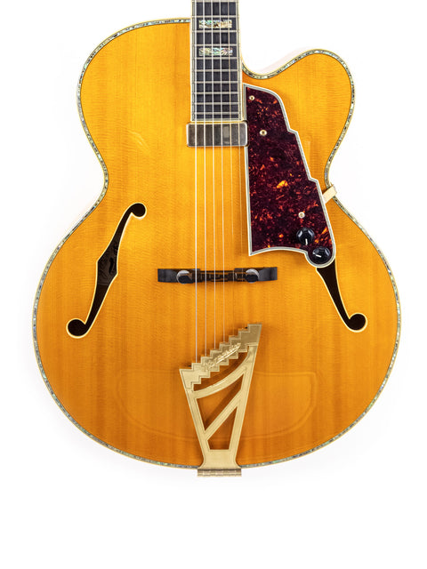 A yellow D’Angelico New Yorker Series Excel EXL-1DP guitar featuring a sleek black pick guard, showcasing its vibrant design.