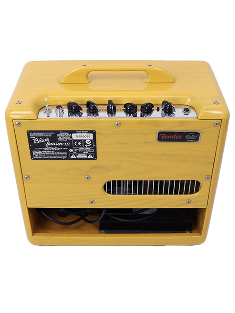 A yellow Fender guitar amplifier with control knobs and a carrying handle.