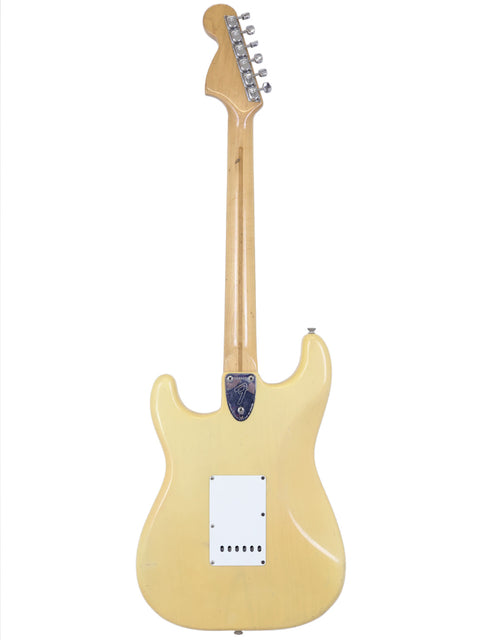  A yellow electric guitar with a white body, specifically a vintage 1954 Fender Stratocaster from the USA.