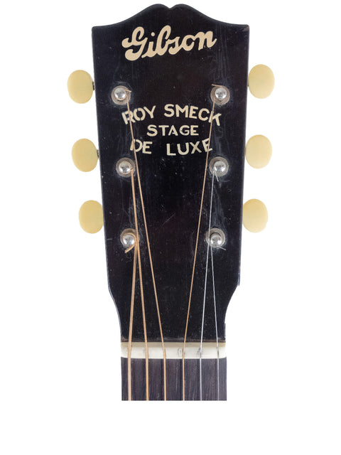 A young boy from 1953 poses with a vintage Gibson Roy Smeck Stage De Luxe guitar, highlighting musical heritage.