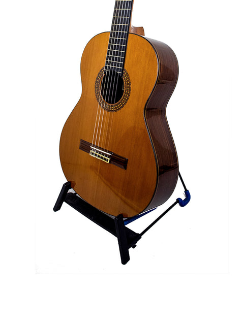 Alhambra C-Series ORO guitar displayed on a stand, featuring a pristine white background that highlights its craftsmanship.