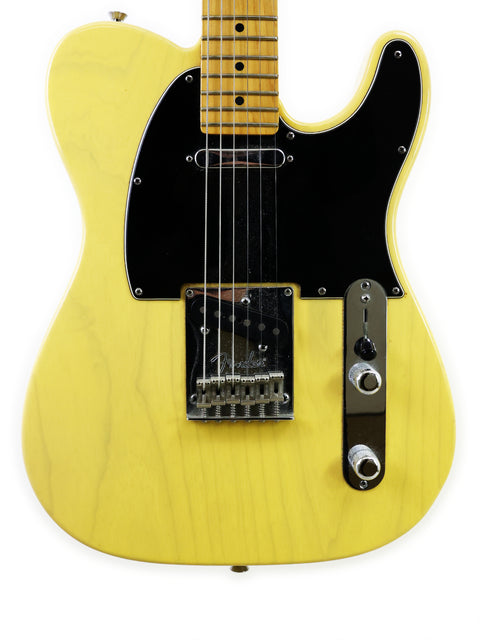 Alt text: Close-up of a yellow Fender Telecaster guitar showing strings, pickup, and control knobs.