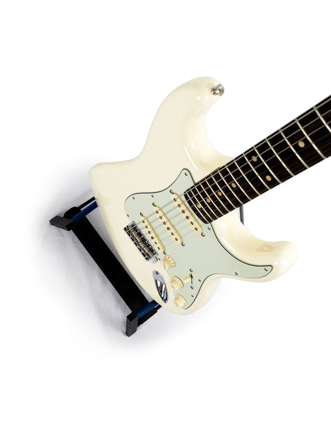 An Olympic White Fender '60s Strat Partscaster electric guitar on a stand, highlighting its Custom Shop craftsmanship, USA 2020.

