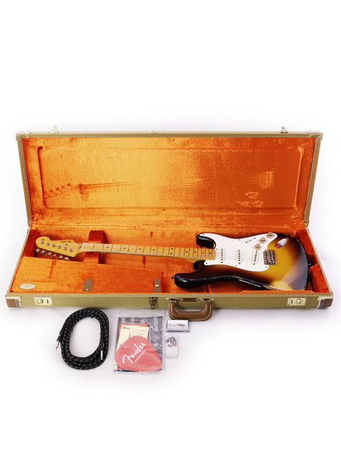 An electric guitar, a Fender Jason Smith Masterbuilt '57 Reissue Stratocaster, is securely placed in its protective case.
