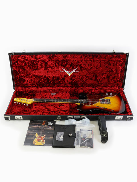 An electric guitar case featuring a Fender ’60s Telecaster Thinline, with guitar picks and other gear inside.