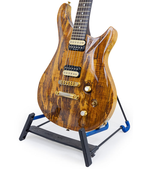 An elegant wooden guitar displayed on a stand, featuring the Ed Roman Quicksilver PRS style, made in the USA, 2004.
