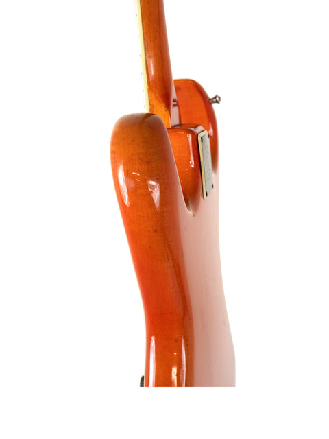 An orange guitar with a wooden body and neck, showcasing the Warmoth Strat Partscaster from the USA, 2012 model.
