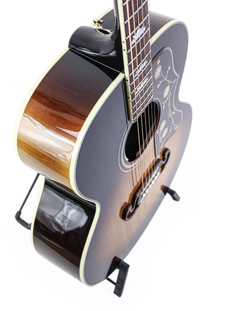 Beautiful Gibson SJ-200 guitar displayed on a stand, highlighting its craftsmanship against a bright white backdrop.
