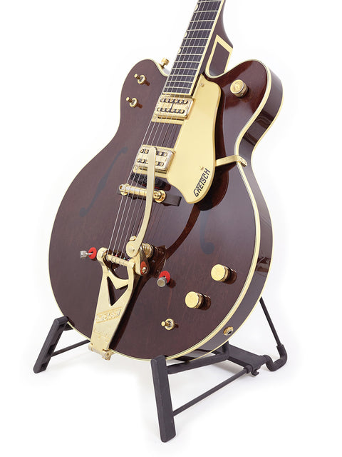 Beautiful brown Gretsch 6122T Chet Atkins guitar with gold accents, showcased on a stand, ideal for any music lover's collection.