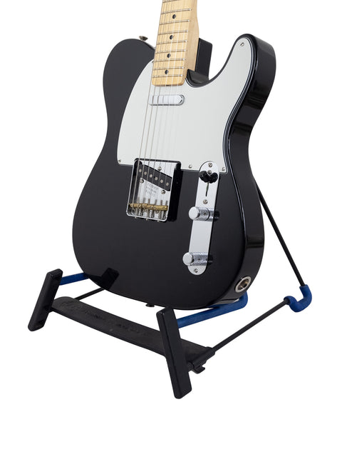 Black Fender guitar displayed on a blue stand, commemorating the 30th Anniversary of the Custom Shop, model ’51 Nocaster.
