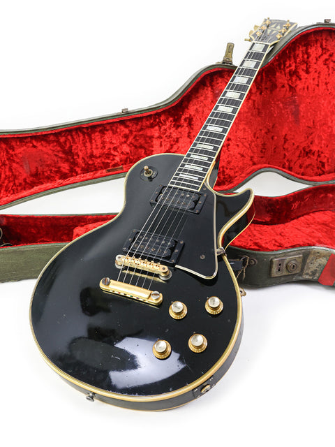Black electric guitar in a red case, showcasing a vintage 1969 Gibson Les Paul Custom from the USA.