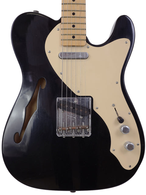 Black electric guitar with a white pickguard, a Fender Custom Shop Telecaster Thinline Closet Classic from 2005.