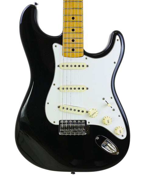 Black electric guitar with a white pickguard, a vintage 1981 Fender Stratocaster, exuding classic rock vibes.
