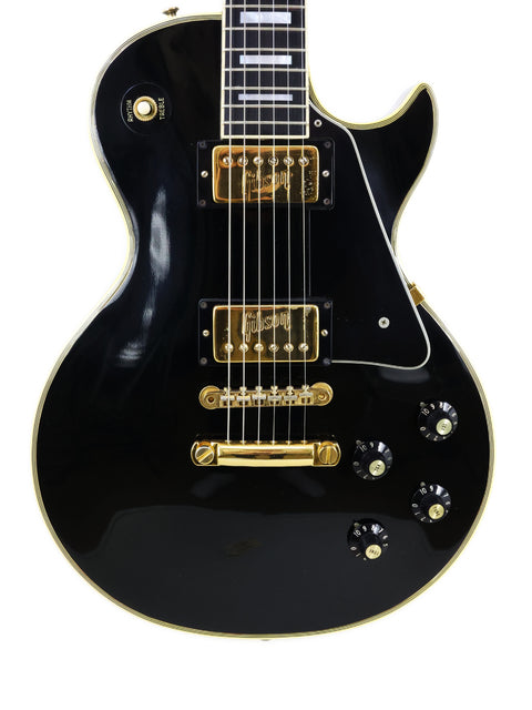 Black electric guitar with gold accents, a vintage 1972 Gibson Les Paul Custom.