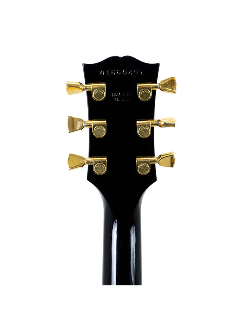 Black guitar headstock with gold hardware, showcasing signatures of BB King and Eric Clapton, made in the USA, 2000.

