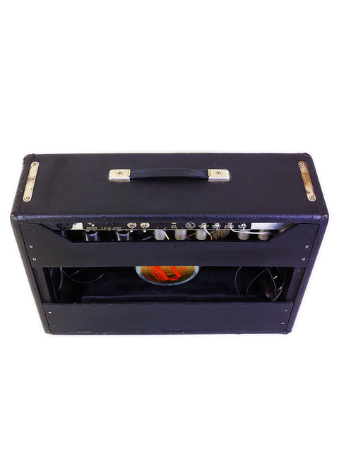 Black vintage Fender Deluxe Reverb amplifier from 1967, adorned with a gold tone knob, representing iconic American design.