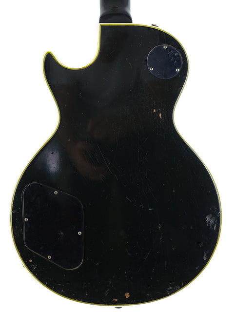 Black vintage Gibson Les Paul Custom guitar from 1969, highlighted by a yellow pickguard.