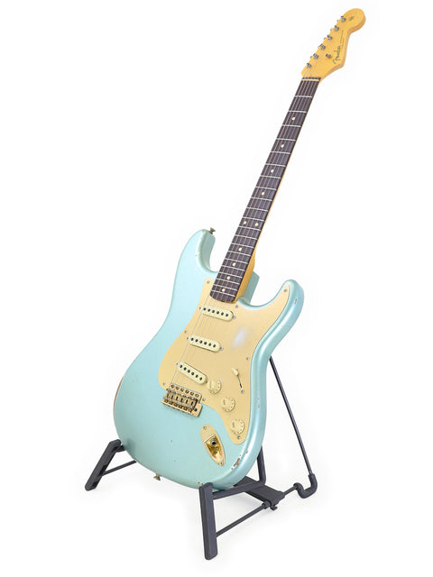Blue Fender Custom Shop Ltd Poblano Partscaster guitar displayed on a stand with a bright white backdrop.
